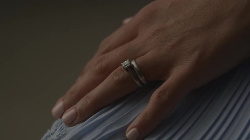 A woman wears a wedding ring on her finger