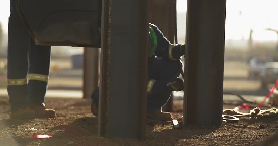 Person drills a large metal pipe on a sunny day