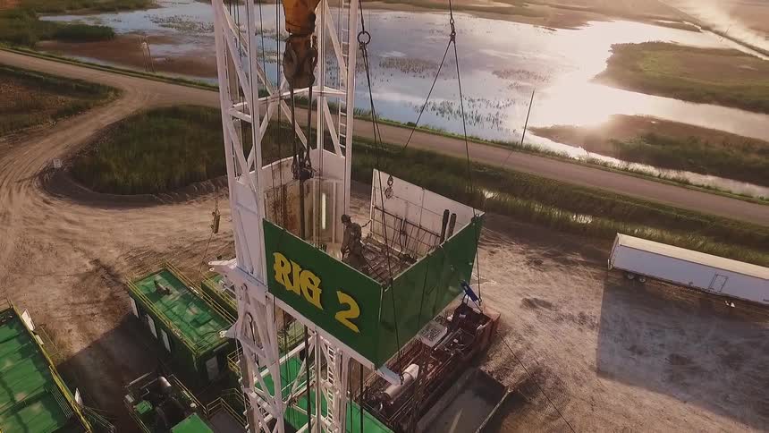 A man stands on the working platform of a drilling rig