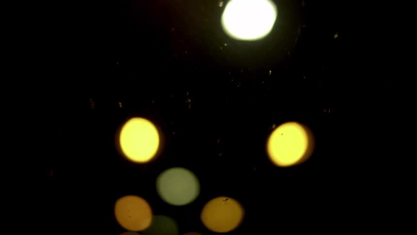 An abstract point-of-view shot from inside a moving vehicle shows tunnel lights blurring into beautiful bokeh