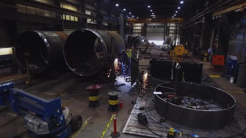 A large warehouse has people working all over