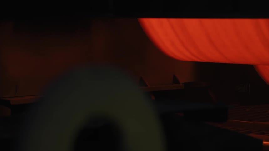A machine is running spinning red material