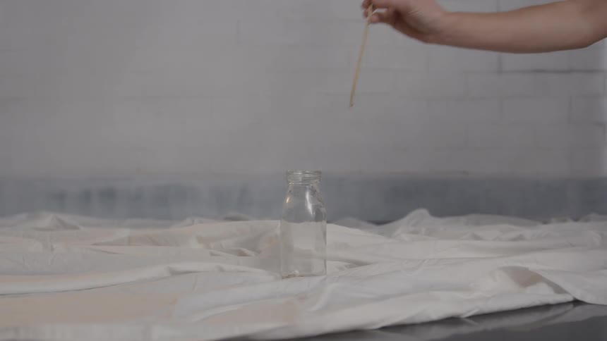 Person sets a gold rose in a glass jar