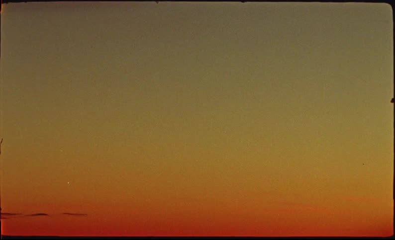 Authentic 8mm film captures the warm, colorful gradient of a minimalist sunset sky with visible grain and light leaks