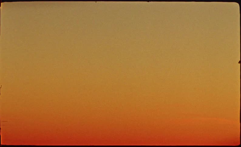 Minimalist vintage film background with a warm orange and red color gradient and authentic film grain