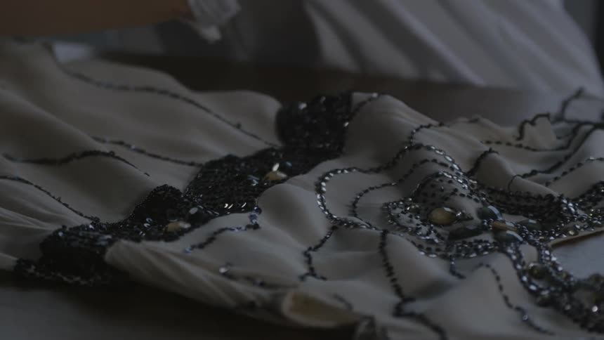 Woman straightens a dress on a table