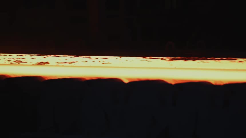 The metal is red hot and rolling slowly