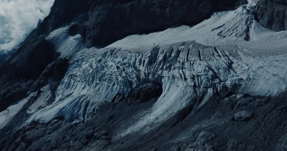 A dramatic, stylized view of a massive glacier with deep crevasses and a dark ice cave on a rugged mountainside