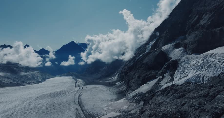 A cinematic shot of a majestic glacier in a mountain valley under a cloudy sky