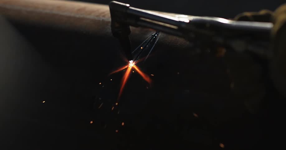 Welder cuts through a piece of metal