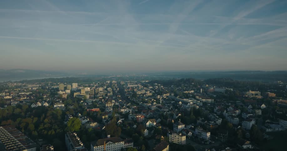 A slow and serene aerial flyover of a sprawling European city waking up in the gentle morning light
