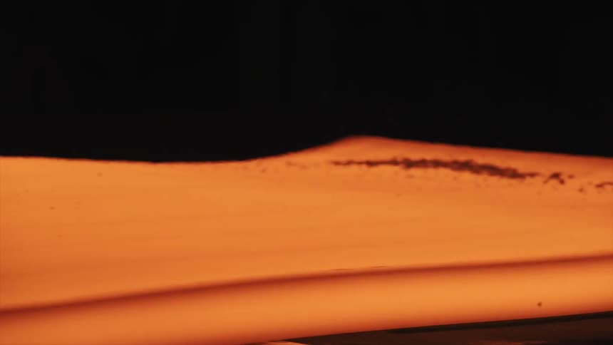 Heated steel moves on rollers in a smelting plant