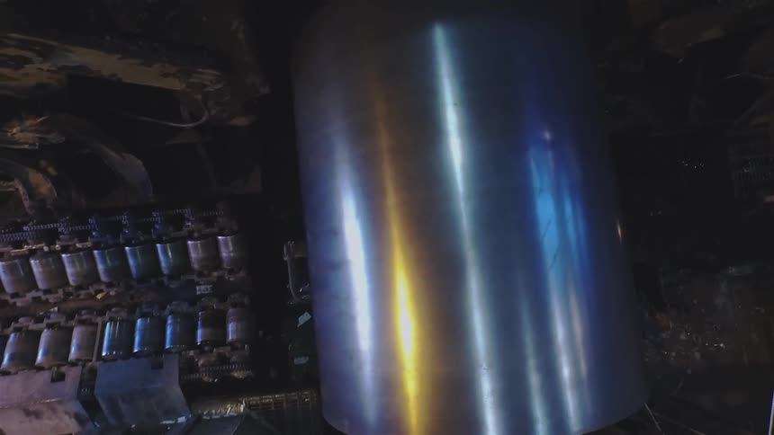 A large metal pipe hangs in a machine