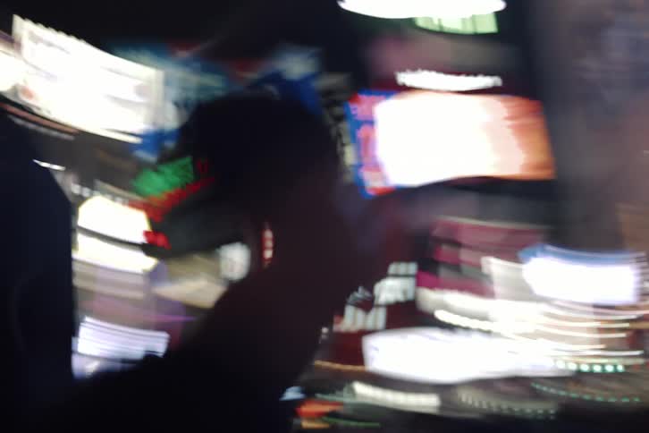 A disorienting motion blur perspective shot walking through a bustling neon-lit city street with a crowd at night