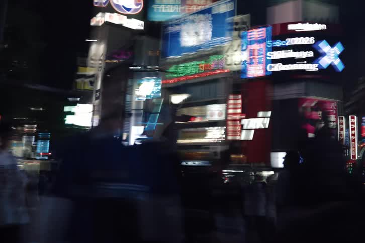 A dizzying first-person view of walking through a crowded city street at night, with neon lights blurring into streaks of color