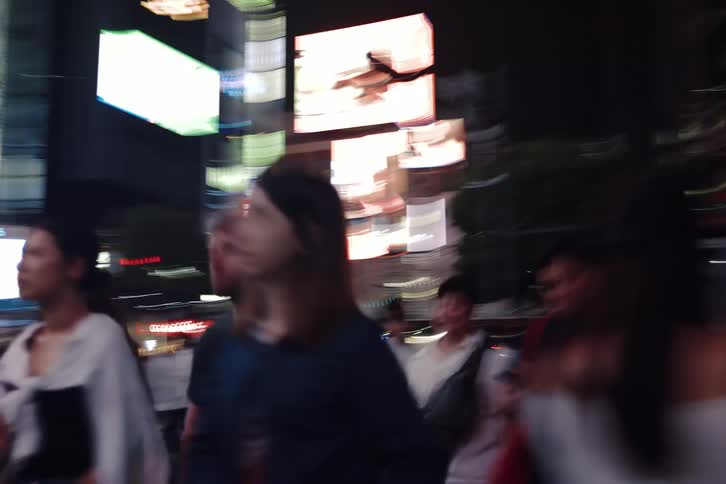 Chaotic first-person view of walking through a crowded city street at night with blurry motion and bright neon lights