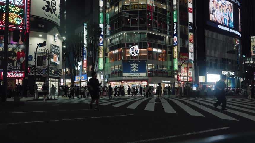 A man runs in slow motion across a bustling, neon-lit street corner in Tokyo at night