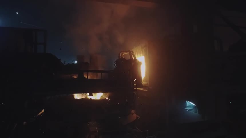 Sparks fly from machinery in a factory setting