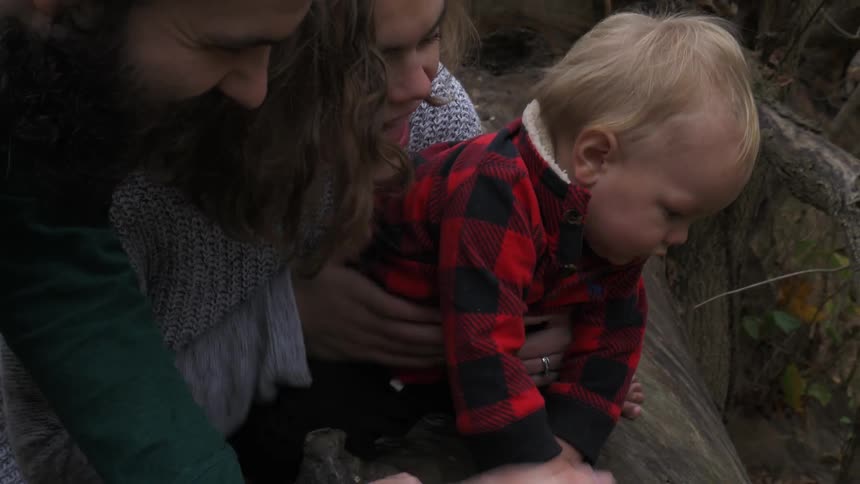 Parents play with their baby outside