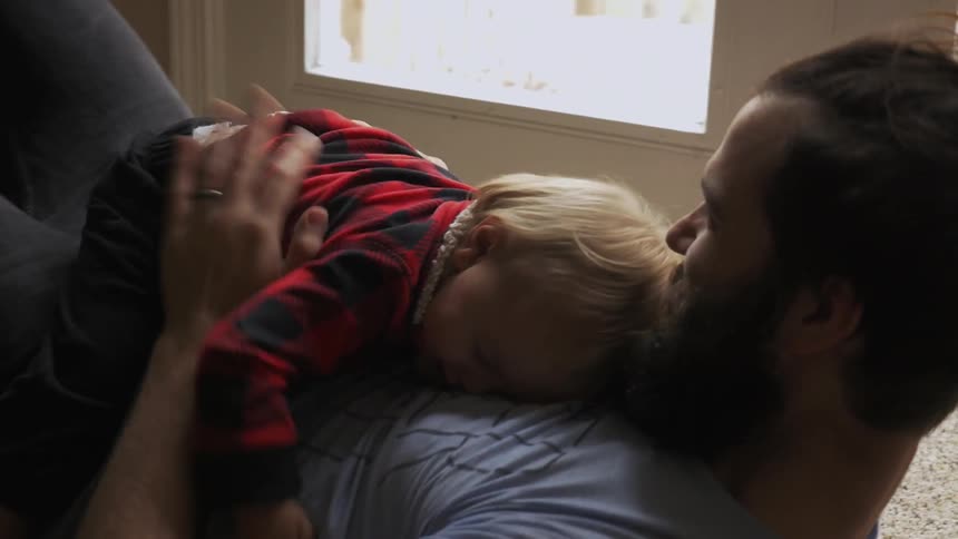 A man plays with a child on the ground