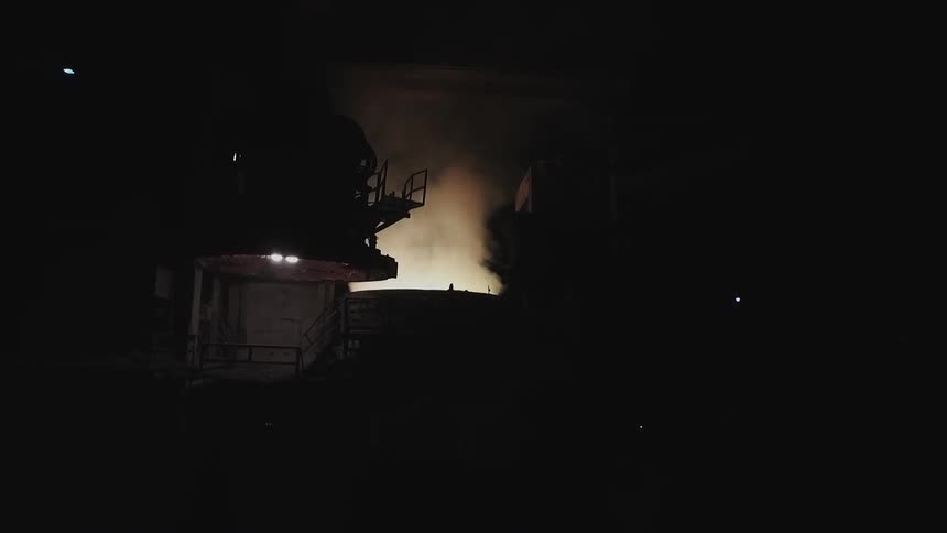 Steam rises from machinery in a factory