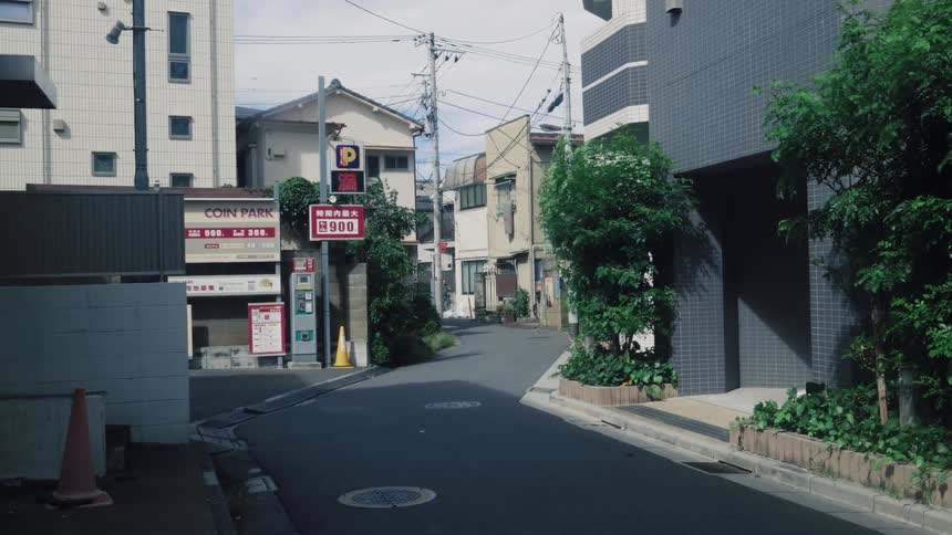 A static shot of an empty side street in a quiet Japanese urban neighborhood