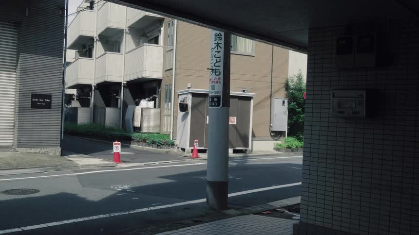 A time-lapse captures the transition from a sunny afternoon to evening on a quiet residential street in Japan