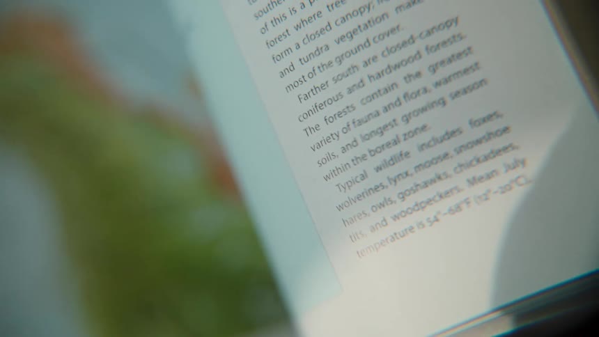 A close-up, out-of-focus shot of someone flipping through the pages of a science textbook