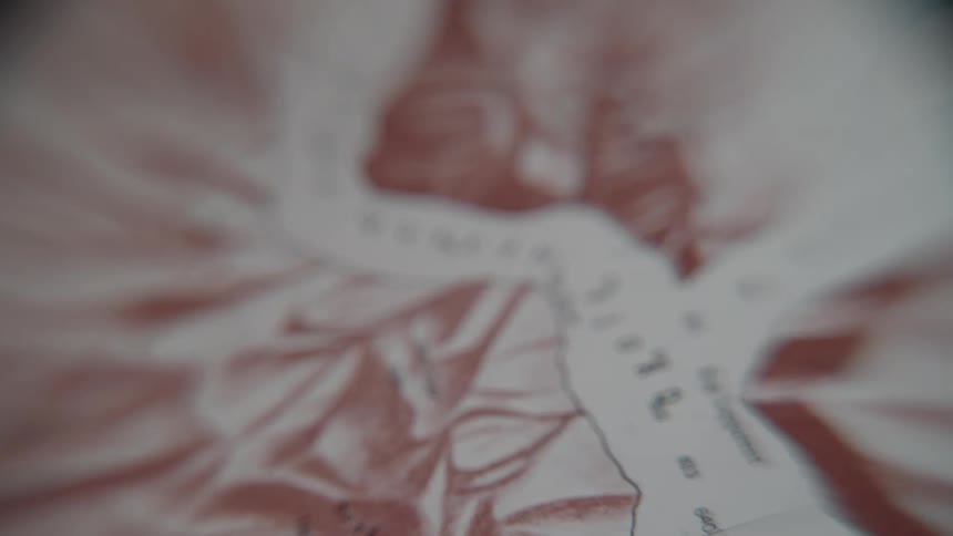 A close-up, slow rack focus shot of a sepia-toned vintage map showing the location of Joseph Fjord