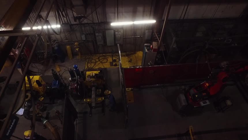 The warehouse is dark with only a few workers