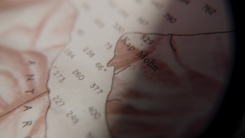 A vintage sepia-toned map of the Antarctic coast is slowly revealed under a moving light