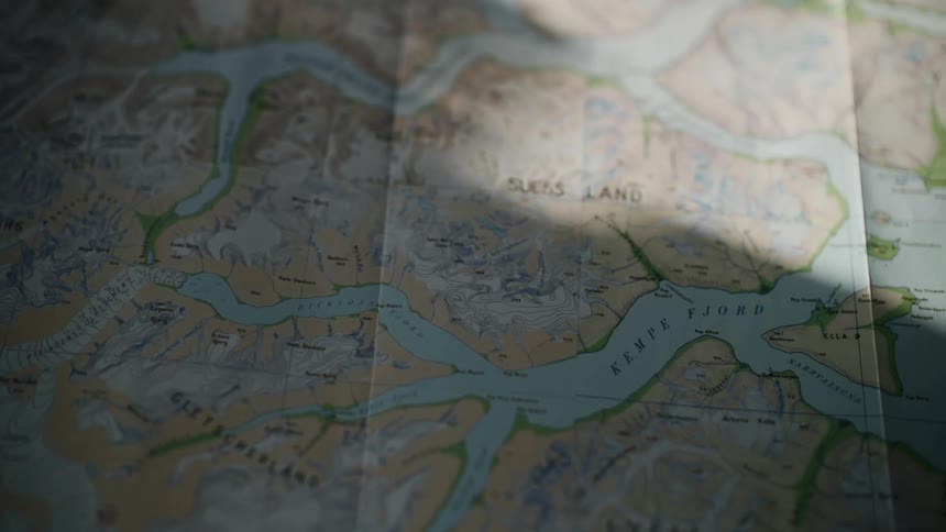 Shadows move across a topographical map of Kempe Fjord and Suess Land