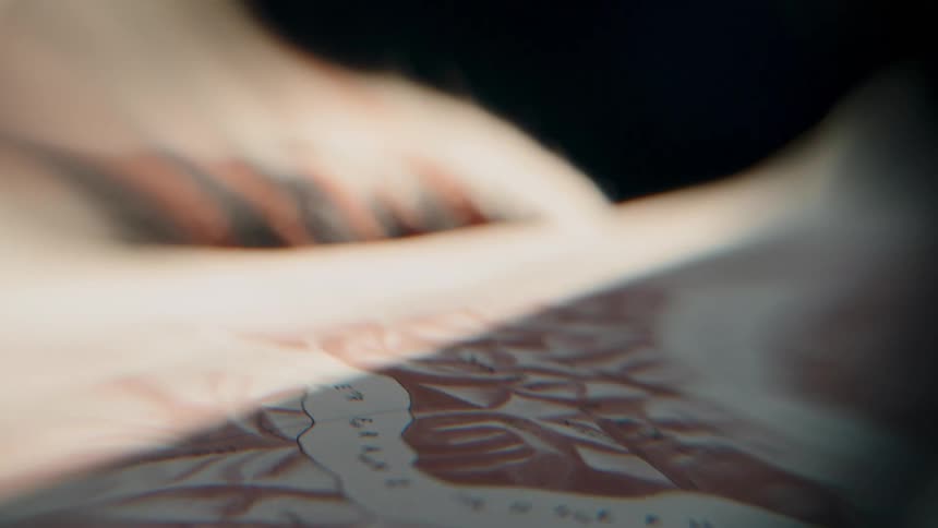 A mysterious, distorted close-up of a Yosemite map is viewed through a lens, with shifting light creating a dreamlike effect
