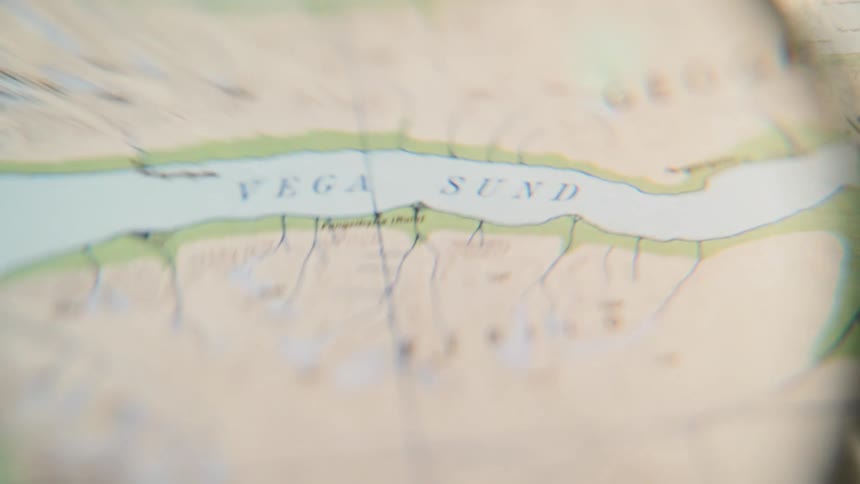 A close-up view of an old map showing the location 'Vega Sund' through a distorted lens