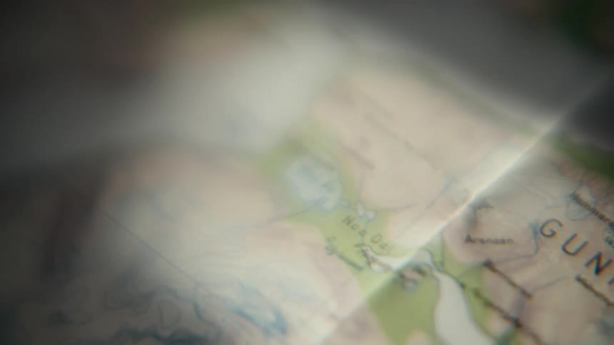 A dreamy, soft focus close-up of a topographical map with shifting light passing over it