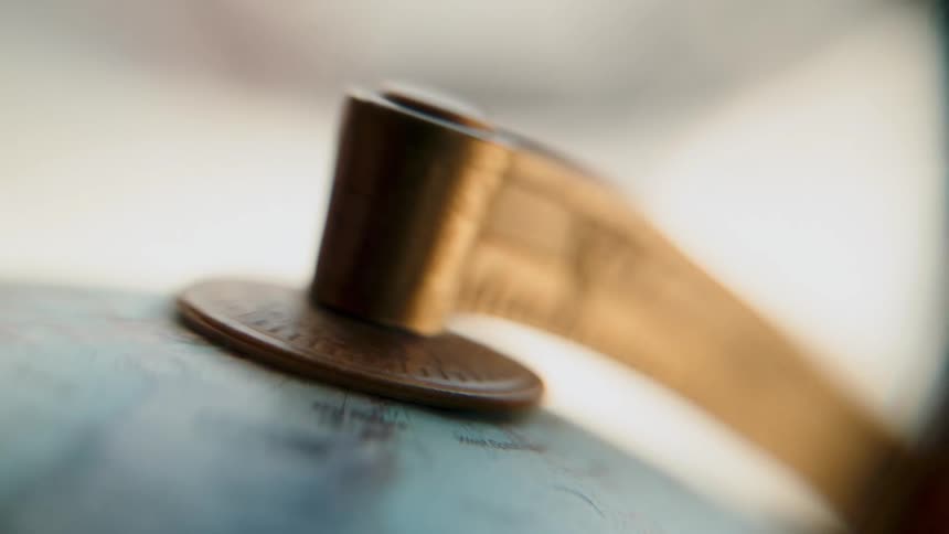 A detailed macro shot captures a vintage world globe slowly spinning on its axis