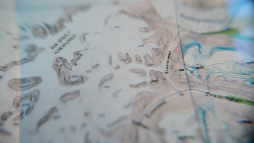 A detailed topographical map comes into focus, highlighting an 'unexplored' region and suggesting adventure