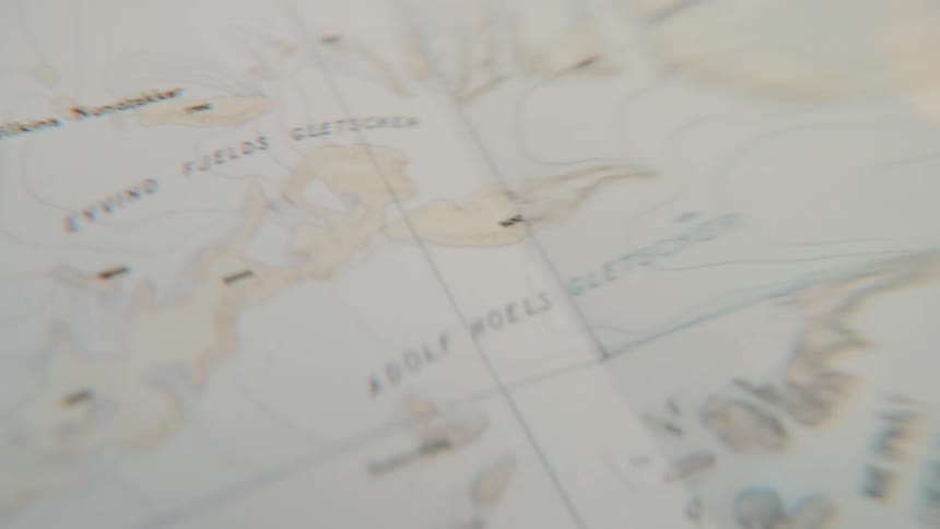 Slowly panning across a detailed navigational map of a remote, icy archipelago
