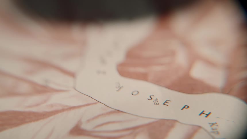 A cinematic macro shot slowly pans across the details of an old, vintage map