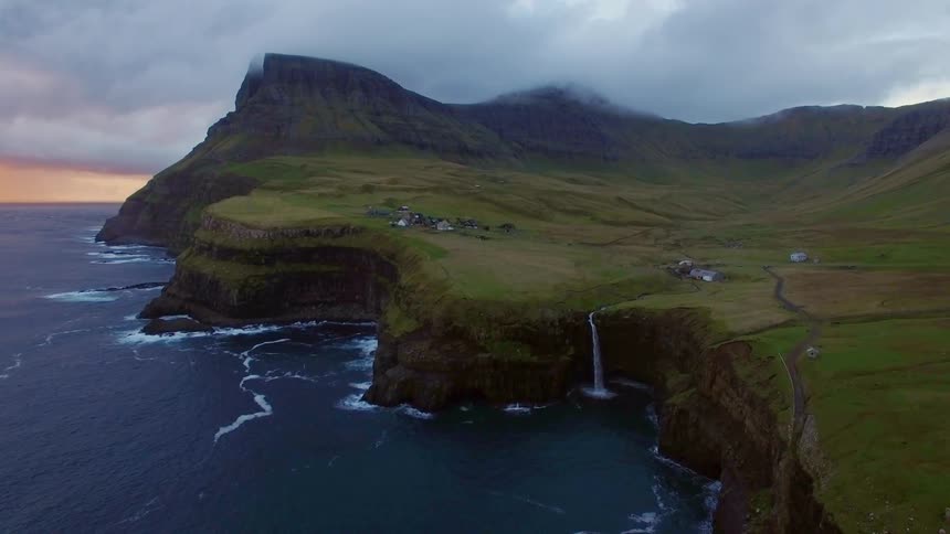 The shoreline has high cliffs with some houses ahead
