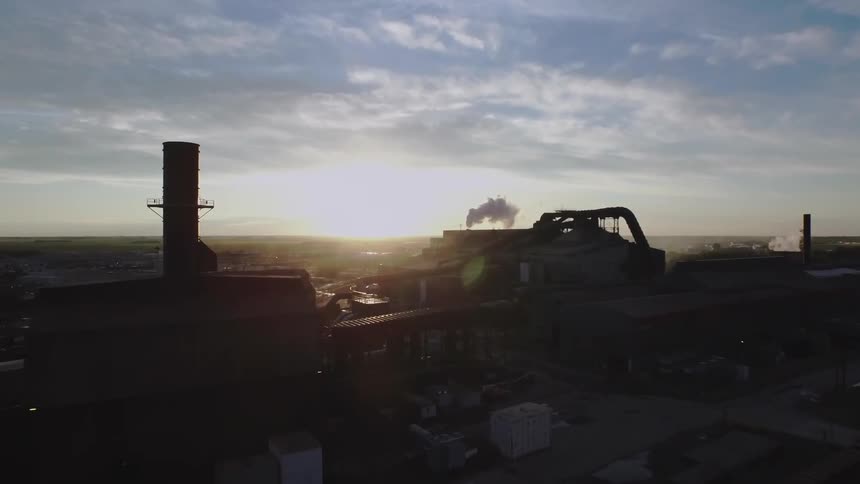 Large industrial building with smoke billowing out of it