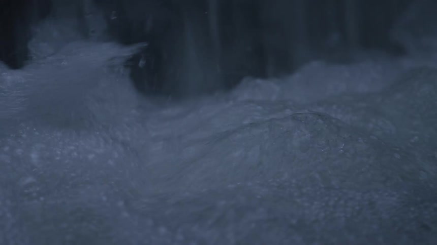 An extreme close-up of bubbling water churning and splashing in slow motion