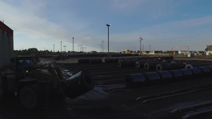 Tractor drives alongside a large building