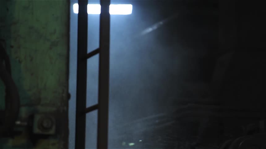 Water and steam spray in this dark warehouse