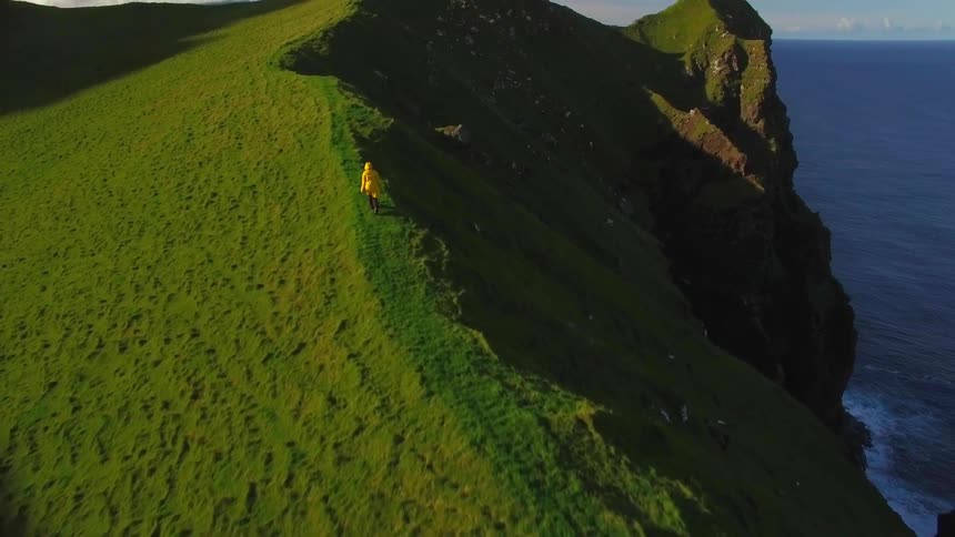 The hill comes to an edge at the top where someone is hiking