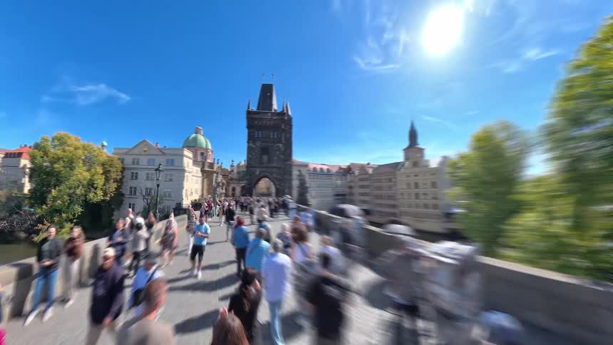 A fast-paced hyperlapse POV walk through the bustling streets of Prague, crossing the famous Charles Bridge and ending in the historic Old Town Square on a sunny day