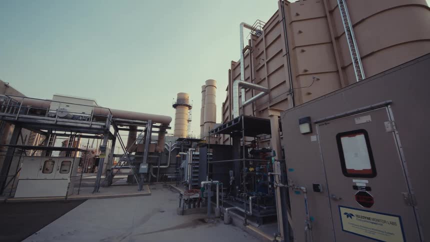 A slow, wide-angle push-in shot reveals the massive and complex infrastructure of an industrial power plant
