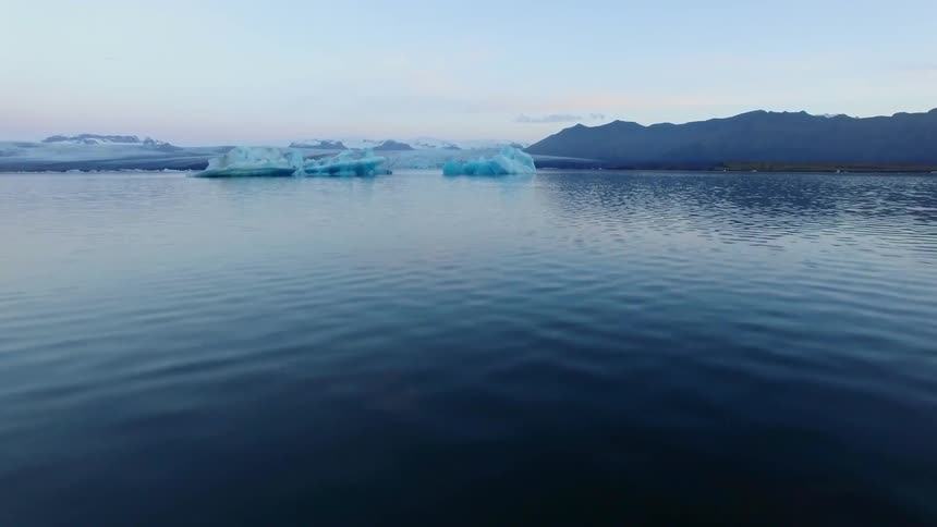 Ice blocks and icebergs float on blue water
