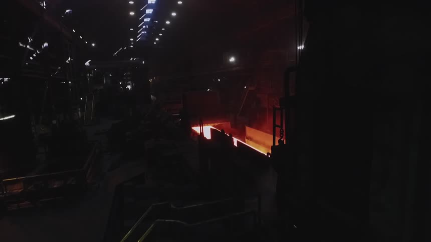 The dark tunnel has a fire in one of the machines
