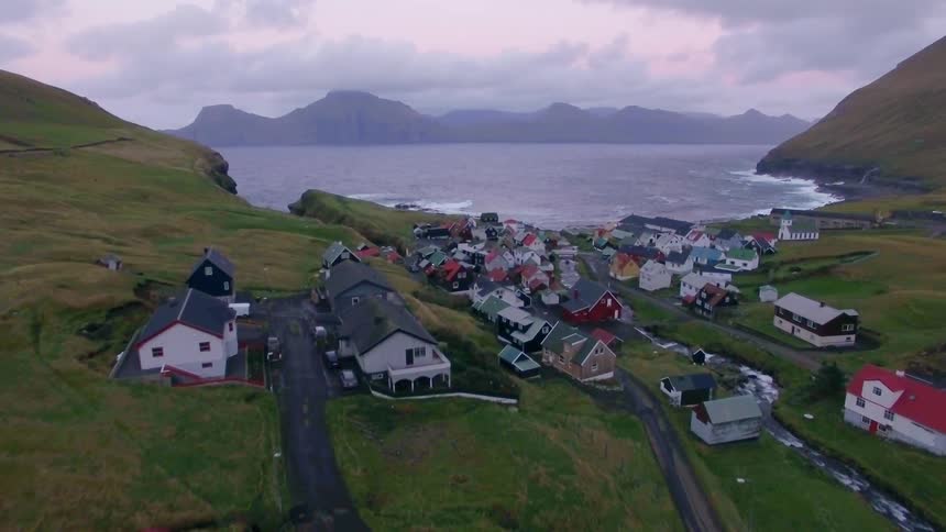Houses sit on a lakeshore on a cloudy day